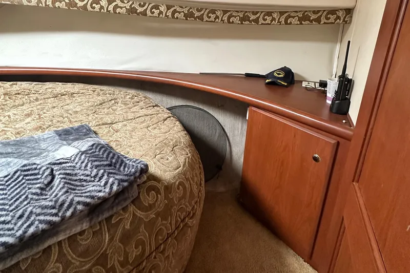 "fish N Chicks" Yacht Photos Pics Cozy interior of 2005 Silverton 34 Convertible yacht with bed and wooden cabinetry.