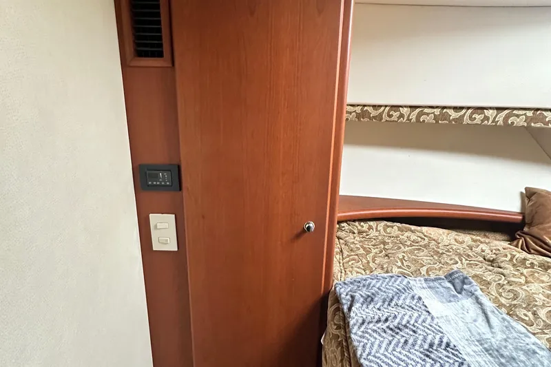 "fish N Chicks" Yacht Photos Pics Interior of 2005 Silverton 34 Convertible yacht with wood paneling and cozy bedding.