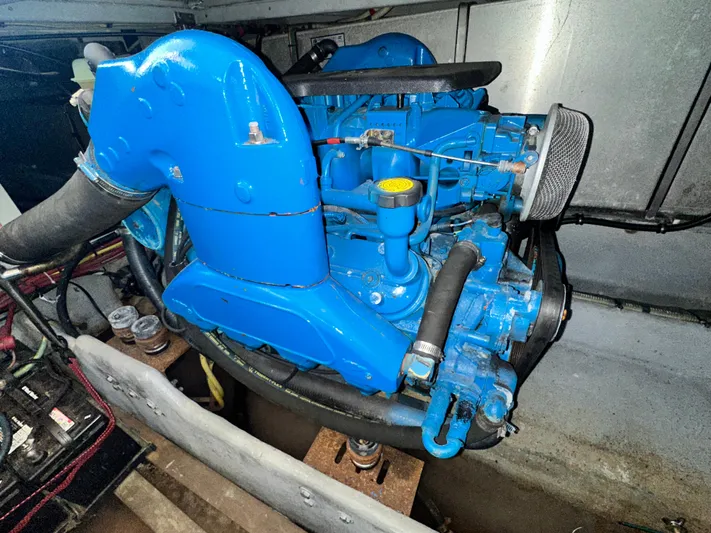 "fish N Chicks" Yacht Photos Pics Engine of a 2005 Silverton 34 Convertible boat, painted blue, in a clean compartment.