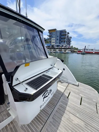 Rio Yacht Photos Pics 2019 Beneteau Gran Turismo 40 docked, featuring an open grill, with waterfront buildings in the background.