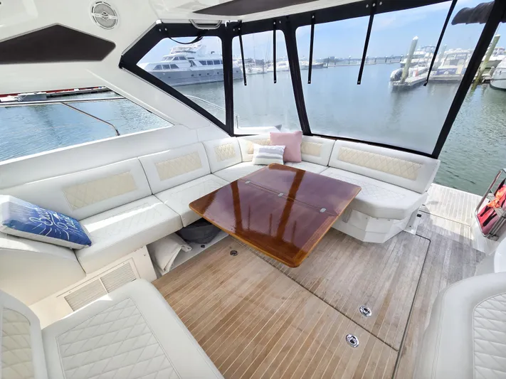 Rio Yacht Photos Pics Luxurious interior of 2019 Beneteau Gran Turismo 40 yacht with elegant seating and wooden table.