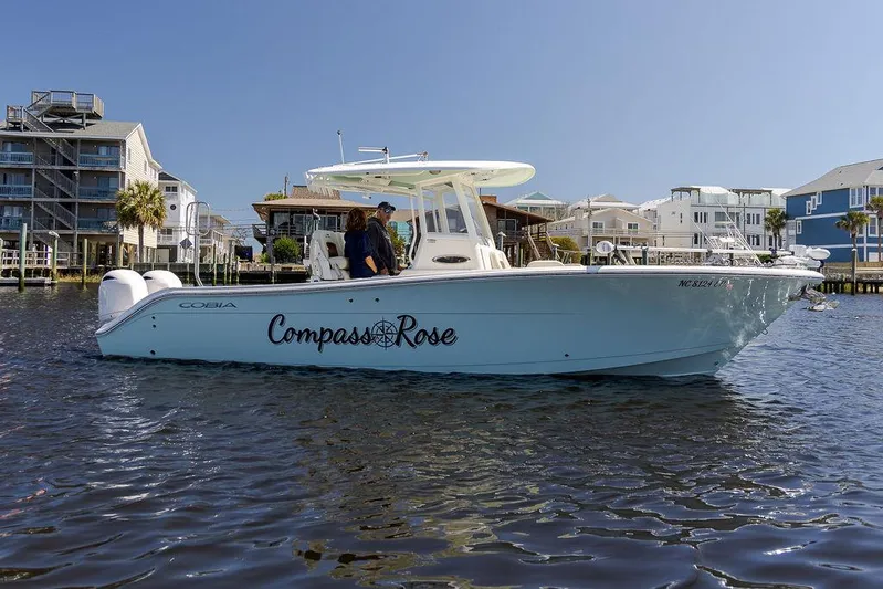 Compass Rose Yacht Photos Pics 2020 Cobia 280 Center Console boat named "Compass Rose" on water near waterfront homes.