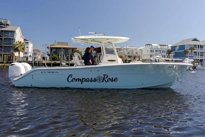 Compass Rose Yacht Photos Pics 2020 Cobia 280 Center Console boat named "Compass Rose" on water near waterfront homes.