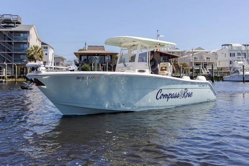 Compass Rose Yacht Photos Pics 2020 Cobia 280 Center Console boat named "Compass Rose" on water near waterfront homes.