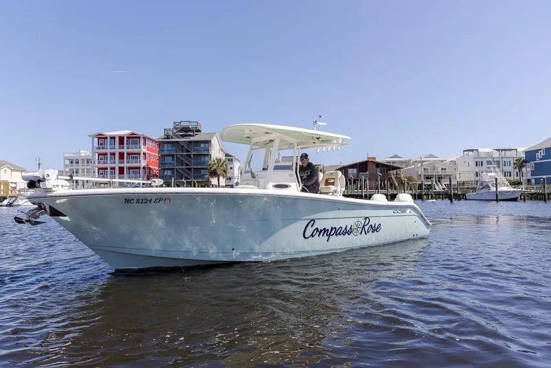 Compass Rose Yacht Photos Pics 2020 Cobia 280 Center Console boat on water near colorful waterfront buildings.