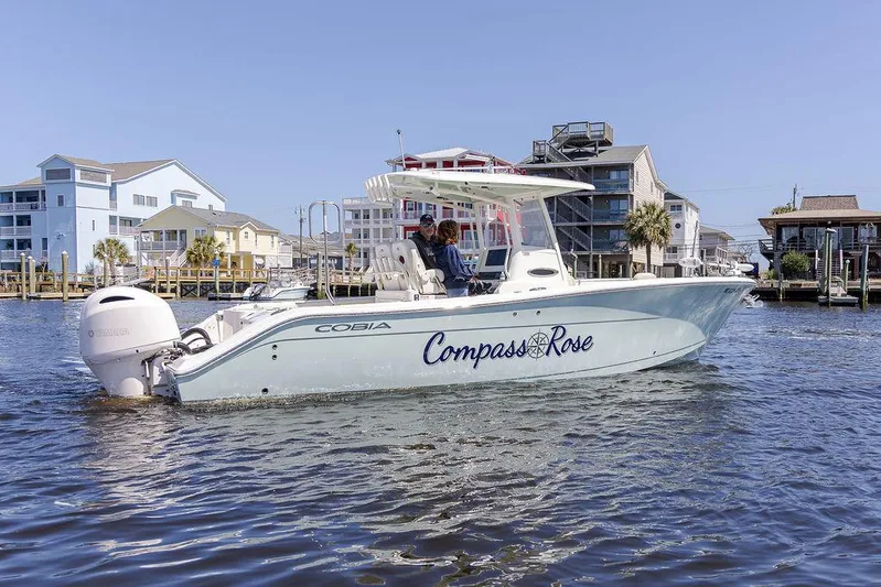 Compass Rose Yacht Photos Pics 2020 Cobia 280 Center Console boat on water near waterfront homes.