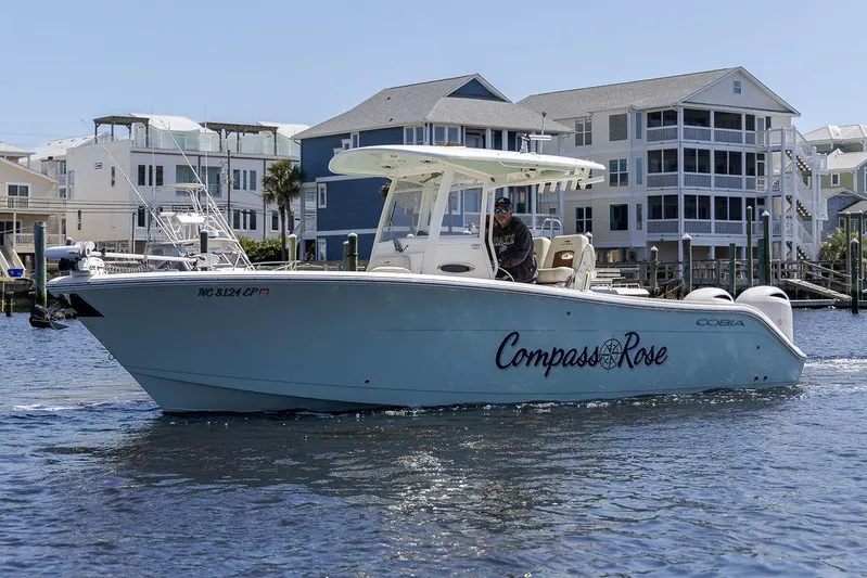 Compass Rose Yacht Photos Pics 2020 Cobia 280 Center Console boat named "Compass Rose" on water near waterfront homes.