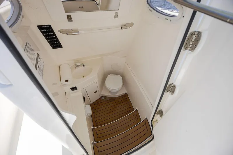 Compass Rose Yacht Photos Pics 2020 Cobia 280 Center Console boat interior with compact bathroom and wooden steps.
