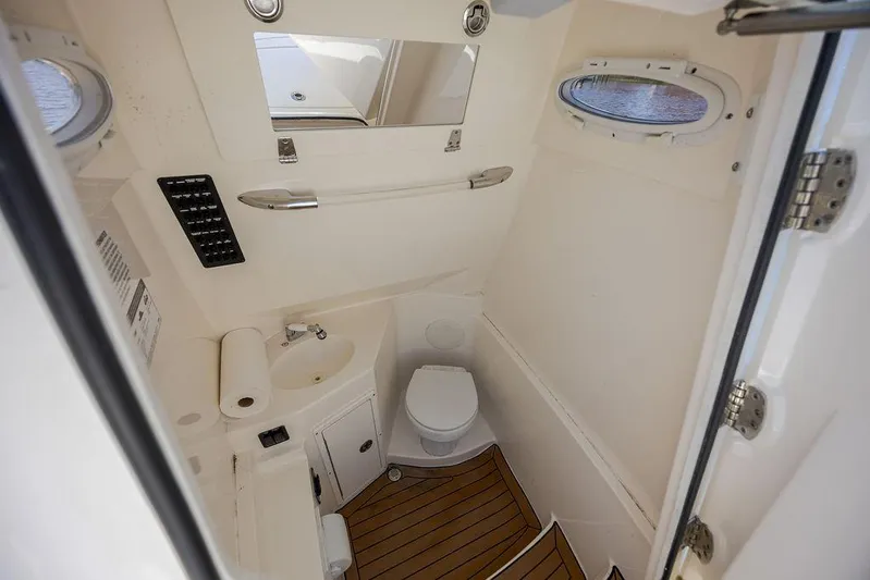Compass Rose Yacht Photos Pics 2020 Cobia 280 Center Console boat bathroom with toilet, sink, and wooden flooring.