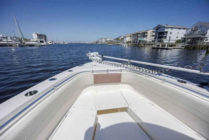 Compass Rose Yacht Photos Pics 2020 Cobia 280 Center Console boat on calm water near marina and waterfront buildings.