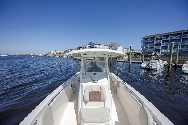 Compass Rose Yacht Photos Pics 2020 Cobia 280 Center Console boat on calm waters near a marina.