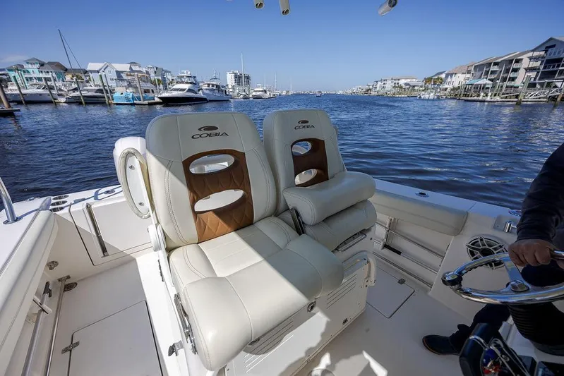 Compass Rose Yacht Photos Pics 2020 Cobia 280 Center Console boat with plush seating, docked in a scenic marina.