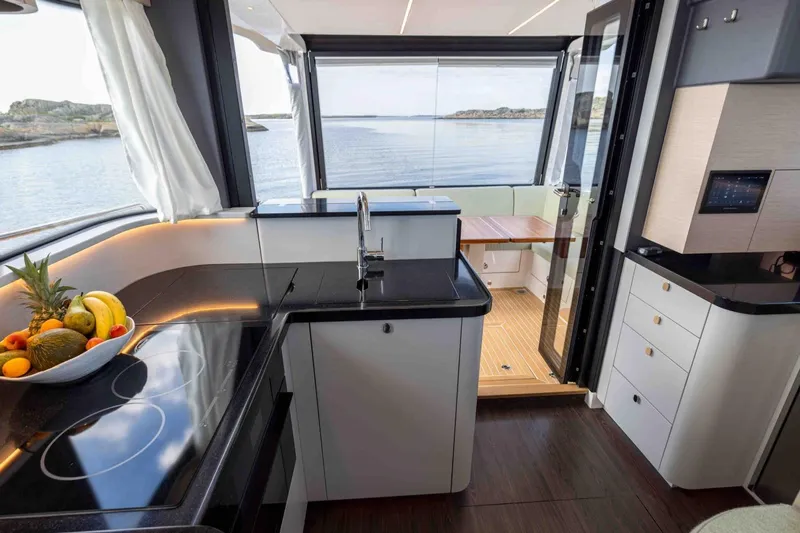  Yacht Photos Pics Luxurious interior of 2026 Nimbus 495 Flybridge yacht with modern kitchen and scenic view.