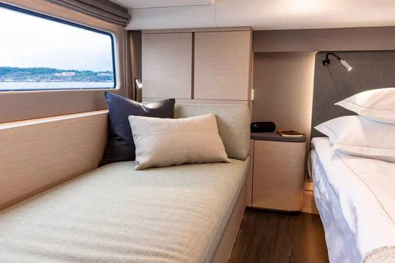  Yacht Photos Pics Luxurious interior of 2026 Nimbus 495 Flybridge yacht with cozy seating and elegant bedding.