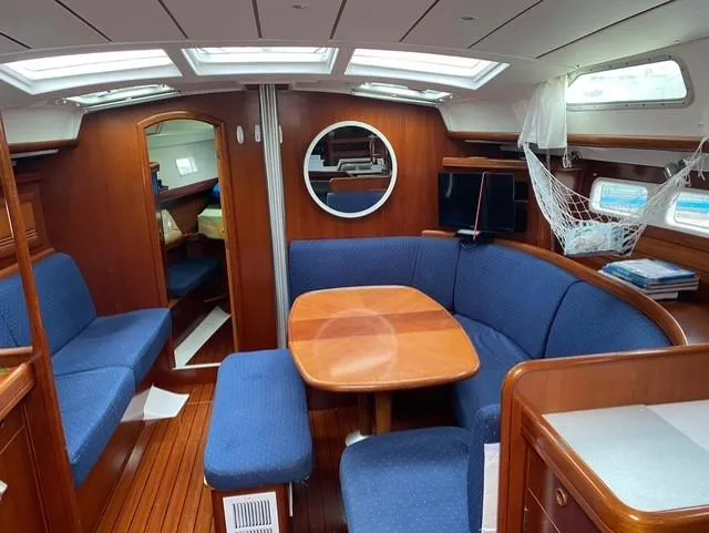 Spirit Bird Yacht Photos Pics Interior of 2004 Beneteau Oceanis 423 sailboat with blue seating and wooden table.