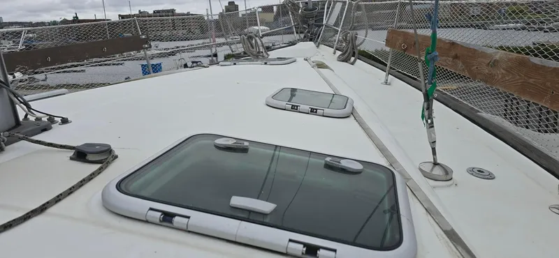 Spirit Bird Yacht Photos Pics 2004 Beneteau Oceanis 423 yacht deck with hatches and safety netting in a marina.