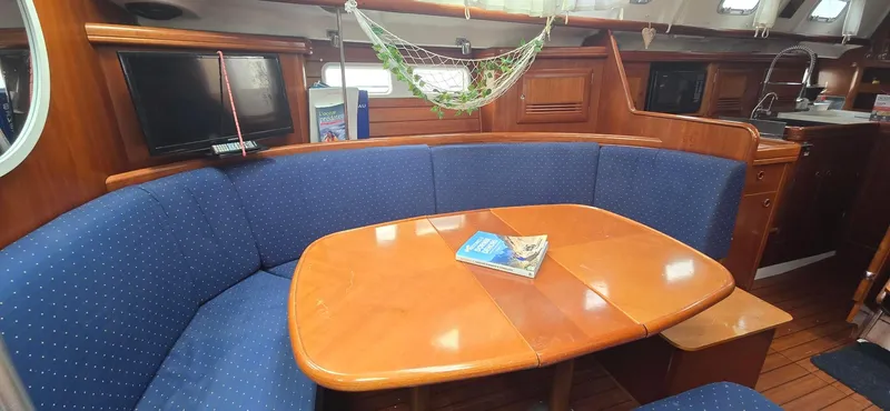 Spirit Bird Yacht Photos Pics Interior of 2004 Beneteau Oceanis 423 yacht with blue seating and wooden table.