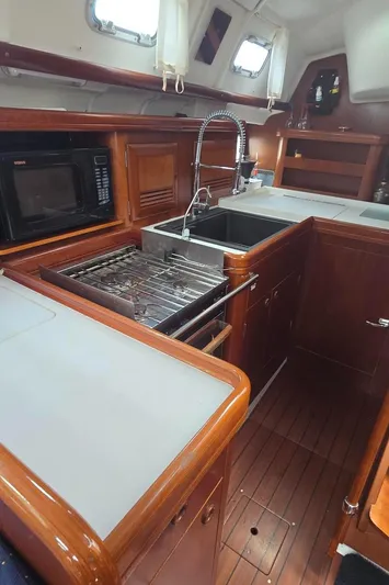 Spirit Bird Yacht Photos Pics 2004 Beneteau Oceanis 423 yacht kitchen with wood cabinetry, stove, sink, and microwave.