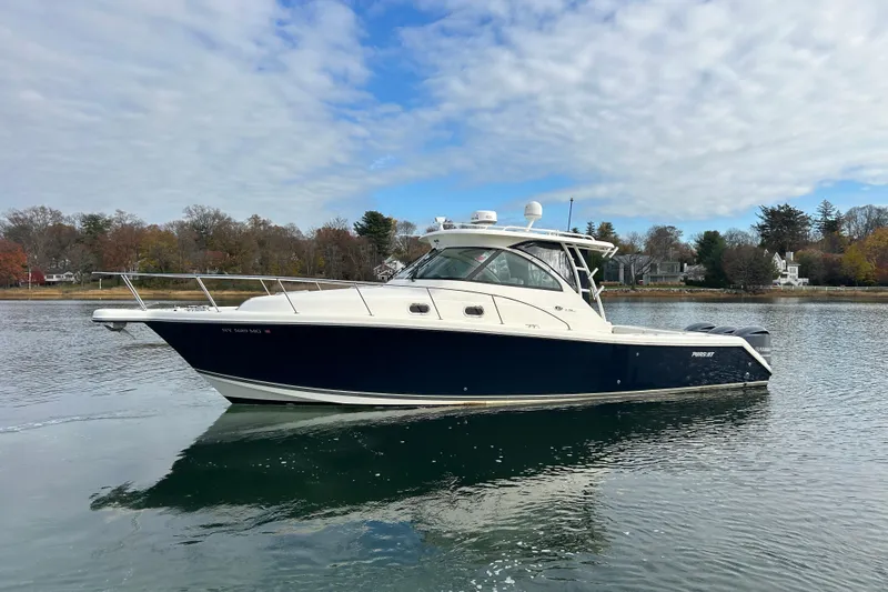  Yacht Photos Pics 2009 Pursuit OS 375 Offshore boat on calm water, under a partly cloudy sky.