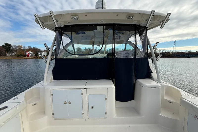  Yacht Photos Pics 2009 Pursuit OS 375 Offshore boat cockpit with clear enclosure on calm water.