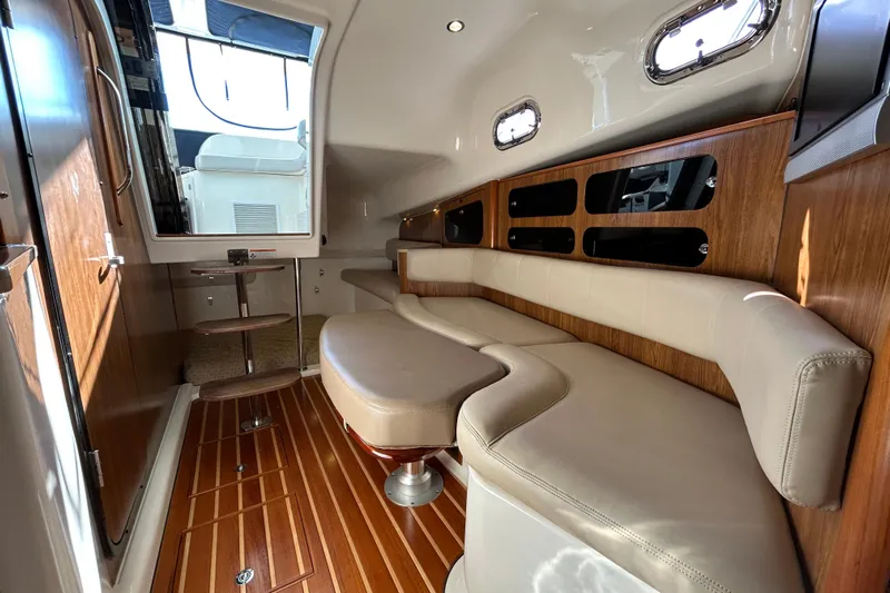  Yacht Photos Pics Luxurious interior of 2009 Pursuit OS 375 Offshore boat with leather seating and wooden accents.