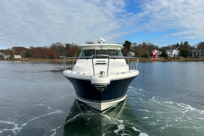  Yacht Photos Pics 2009 Pursuit OS 375 Offshore boat on calm water, scenic background.
