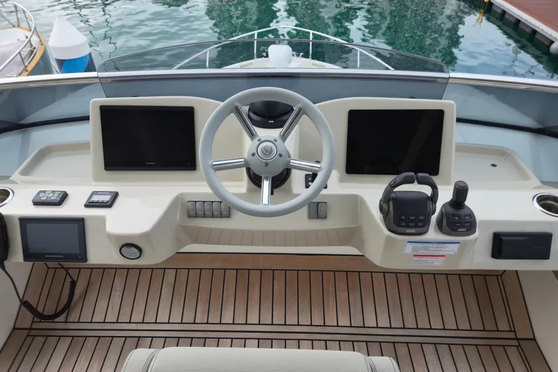  Yacht Photos Pics 2025 Absolute Navetta 53 helm with modern controls and dual screens, docked by water.