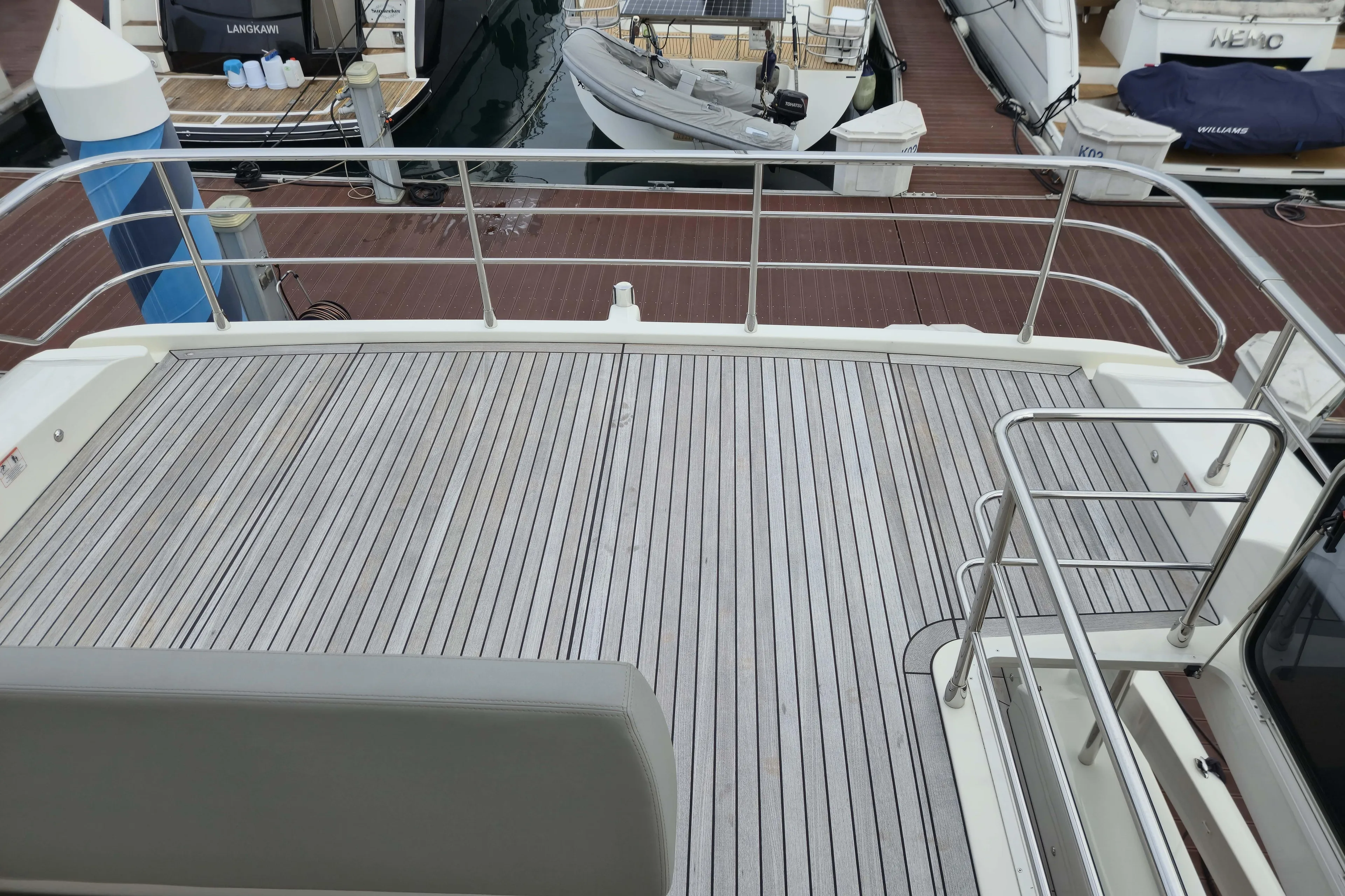  Yacht Photos Pics Deck view of 2025 Absolute Navetta 53 yacht at marina, featuring sleek railings.