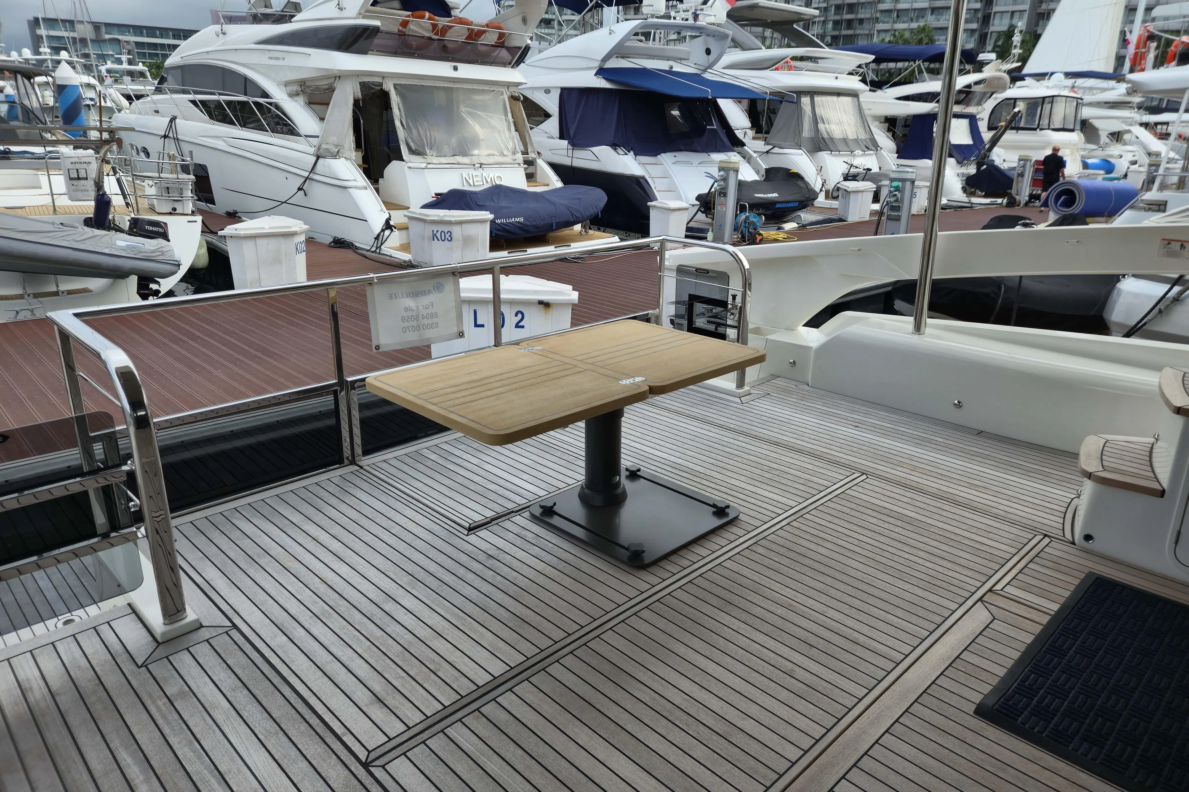  Yacht Photos Pics Luxury yacht deck of 2025 Absolute Navetta 53, featuring elegant wood flooring and table.