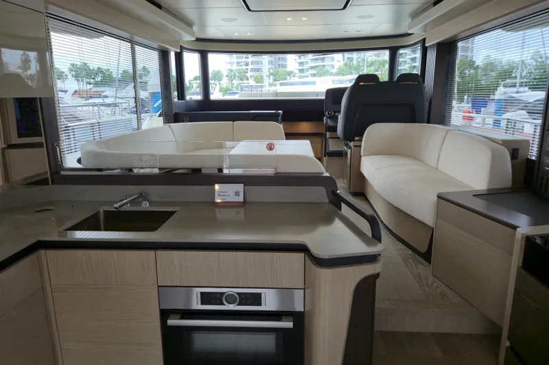  Yacht Photos Pics Luxurious interior of 2025 Absolute Navetta 53 yacht with modern kitchen and seating area.
