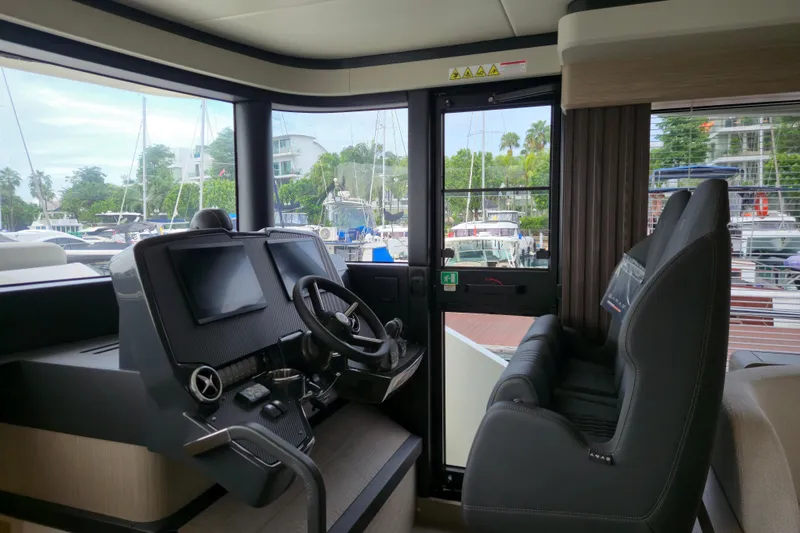  Yacht Photos Pics Interior helm of 2025 Absolute Navetta 53 yacht with modern controls and marina view.