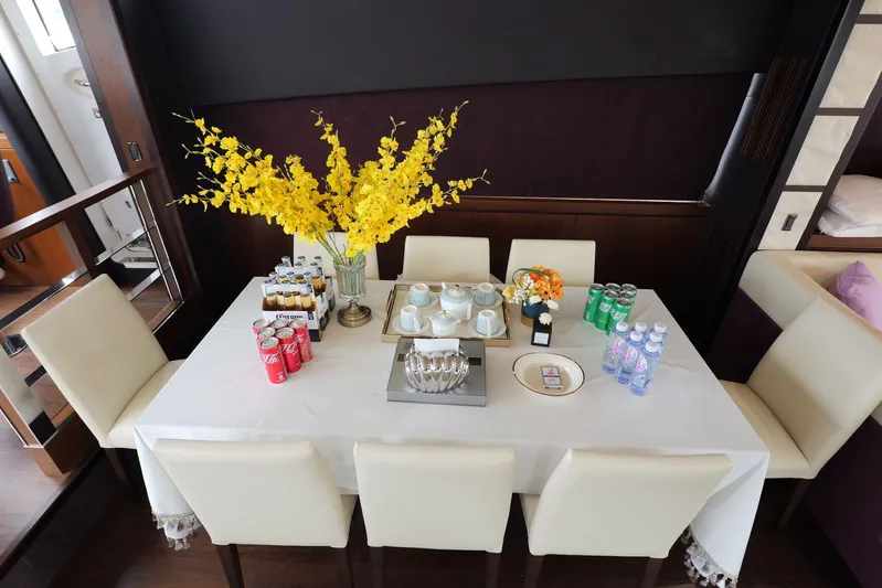  Yacht Photos Pics Dining table on 2013 Sunseeker Manhattan 73 yacht with drinks and yellow floral centerpiece.