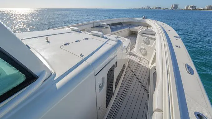Reel Addiction Yacht Photos Pics HCB Suenos 53 yacht deck, 2016 model, cruising on calm ocean waters near a city skyline.