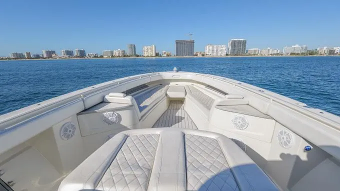 Reel Addiction Yacht Photos Pics Luxurious 2016 HCB Suenos 53 yacht with spacious seating, cruising near a city skyline.