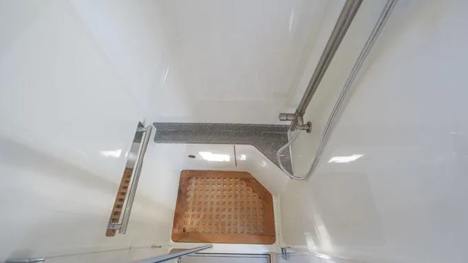 Reel Addiction Yacht Photos Pics Shower area in 2016 HCB Suenos 53 boat with wooden mat and stainless steel fixtures.