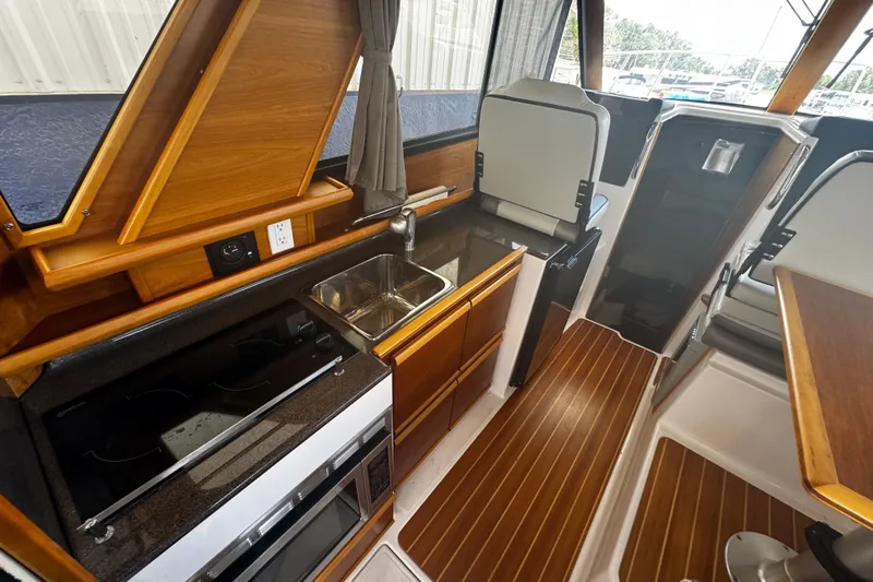 Happy Ours Yacht Photos Pics 2019 Cutwater C-28 boat interior with modern kitchen, wood accents, and sleek design.