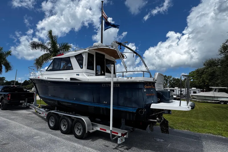 Happy Ours Yacht Photos Pics 2019 Cutwater C-28 boat on trailer, parked under a blue sky with palm trees.