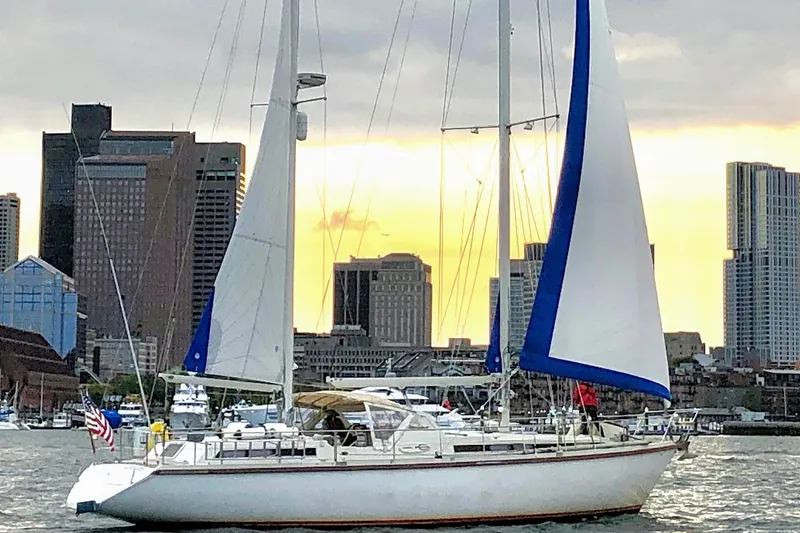 Iteration Yacht Photos Pics 1994 Amel 53 Super Maramu sailboat in urban harbor at sunset.