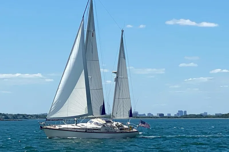 Iteration Yacht Photos Pics Sailing yacht Amel 53 Super Maramu 1994 on open water with city skyline background.