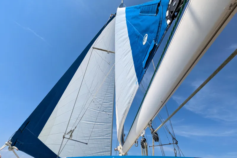 Iteration Yacht Photos Pics Sails of a 1994 Amel 53 Super Maramu yacht against a clear blue sky.