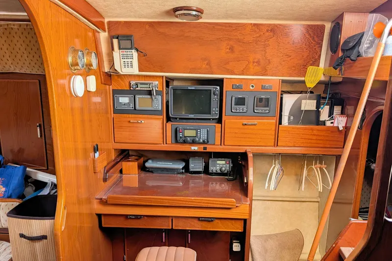 Iteration Yacht Photos Pics 1994 Amel 53 Super Maramu yacht interior with navigation equipment and wooden cabinetry.