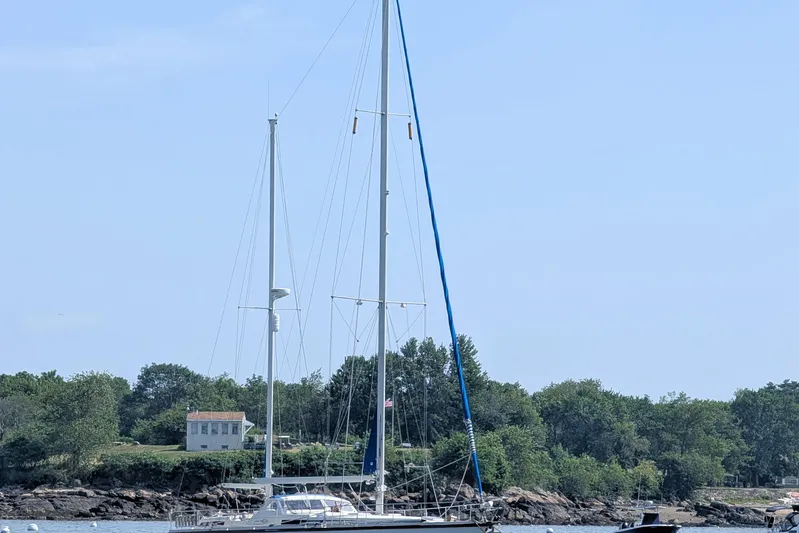 Iteration Yacht Photos Pics Sailboat Amel 53 Super Maramu 1994 anchored near a scenic shoreline.