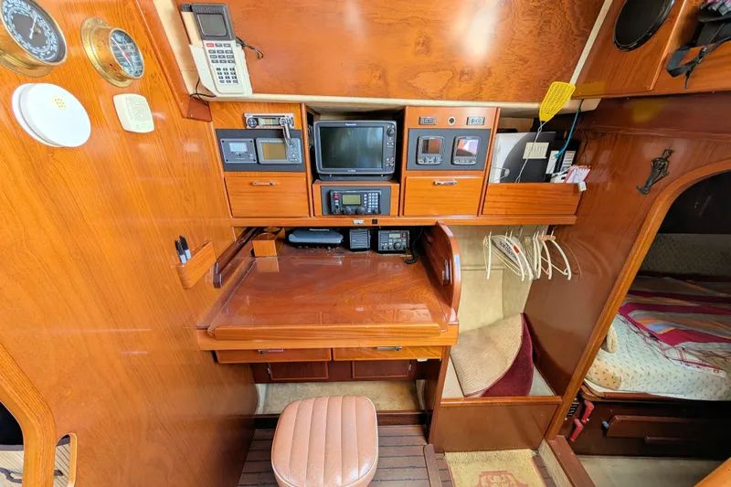 Iteration Yacht Photos Pics Navigation station of 1994 Amel 53 Super Maramu yacht with wooden interior and electronic equipment.