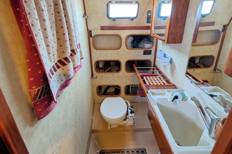 Iteration Yacht Photos Pics Bathroom interior of 1994 Amel 53 Super Maramu yacht, featuring sink, toilet, and storage.