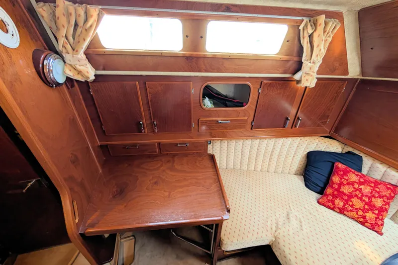 Iteration Yacht Photos Pics Cozy interior of 1994 Amel 53 Super Maramu sailboat with wooden cabinetry and cushioned seating.