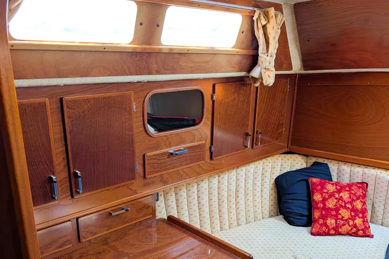 Iteration Yacht Photos Pics Interior of 1994 Amel 53 Super Maramu yacht with wood cabinetry and cozy seating area.