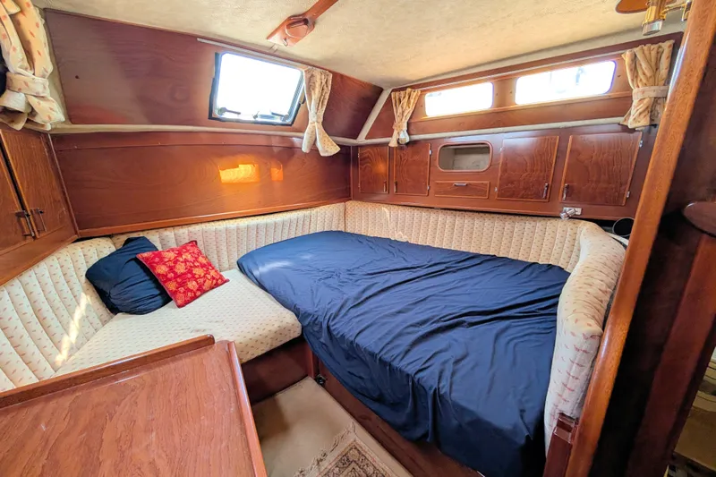 Iteration Yacht Photos Pics Cozy cabin interior of 1994 Amel 53 Super Maramu yacht with wood paneling and comfortable bedding.