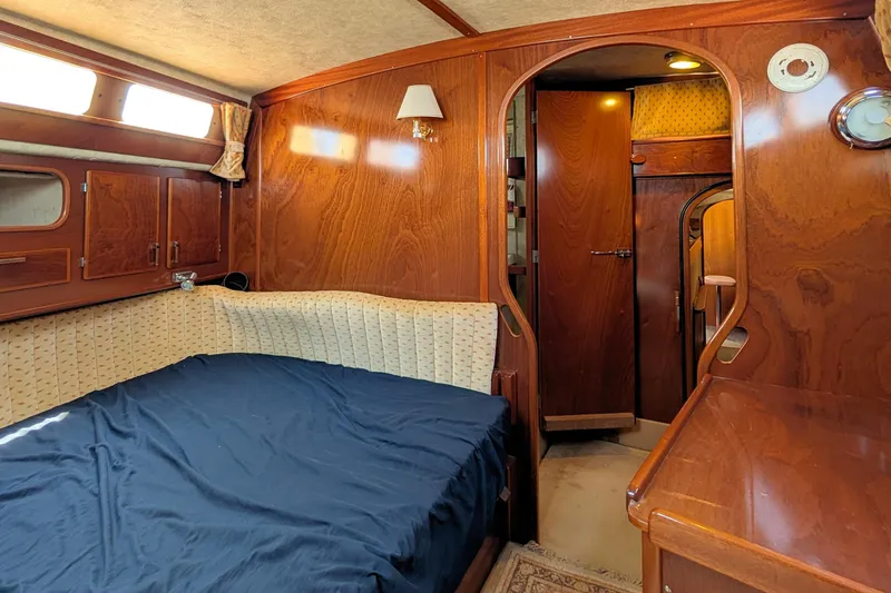 Iteration Yacht Photos Pics Interior of 1994 Amel 53 Super Maramu yacht with wooden finish and cozy bed.