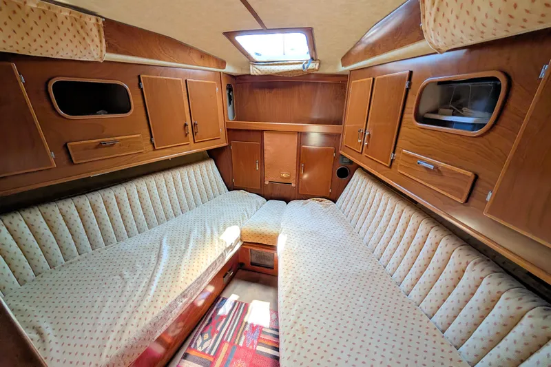 Iteration Yacht Photos Pics Interior of 1994 Amel 53 Super Maramu yacht with cozy seating and wooden cabinetry.