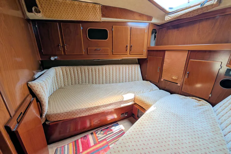 Iteration Yacht Photos Pics Cozy cabin interior of 1994 Amel 53 Super Maramu sailboat with wood paneling and cushioned seating.